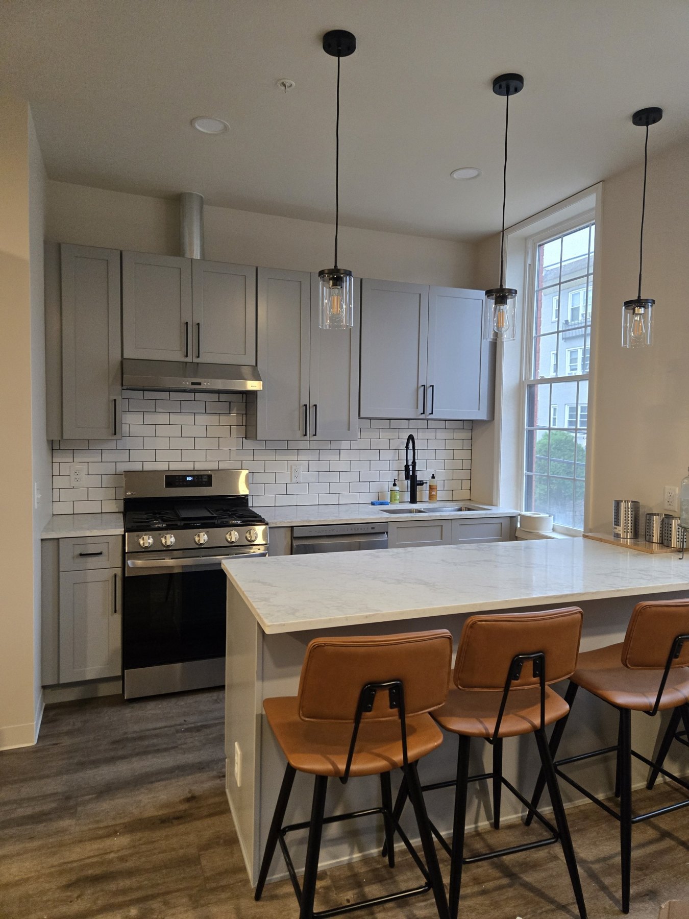 Kitchen with gray cabinetry, white counters and a large window