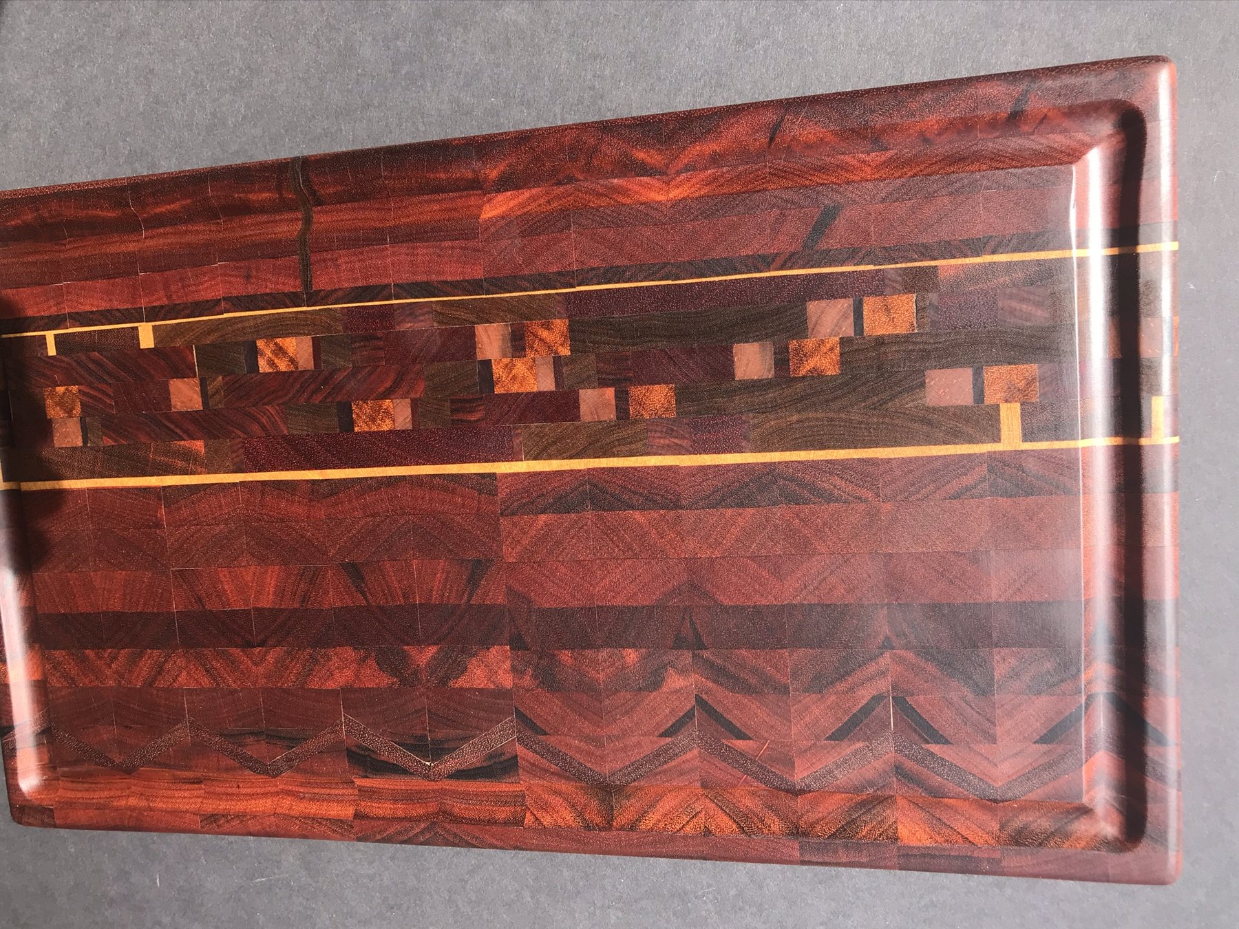 Wood cutting board with contrasting geometric patterns