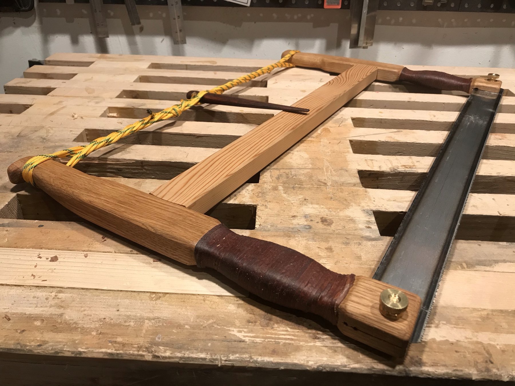 Wooden frame saw with a tensioning cord on a workbench