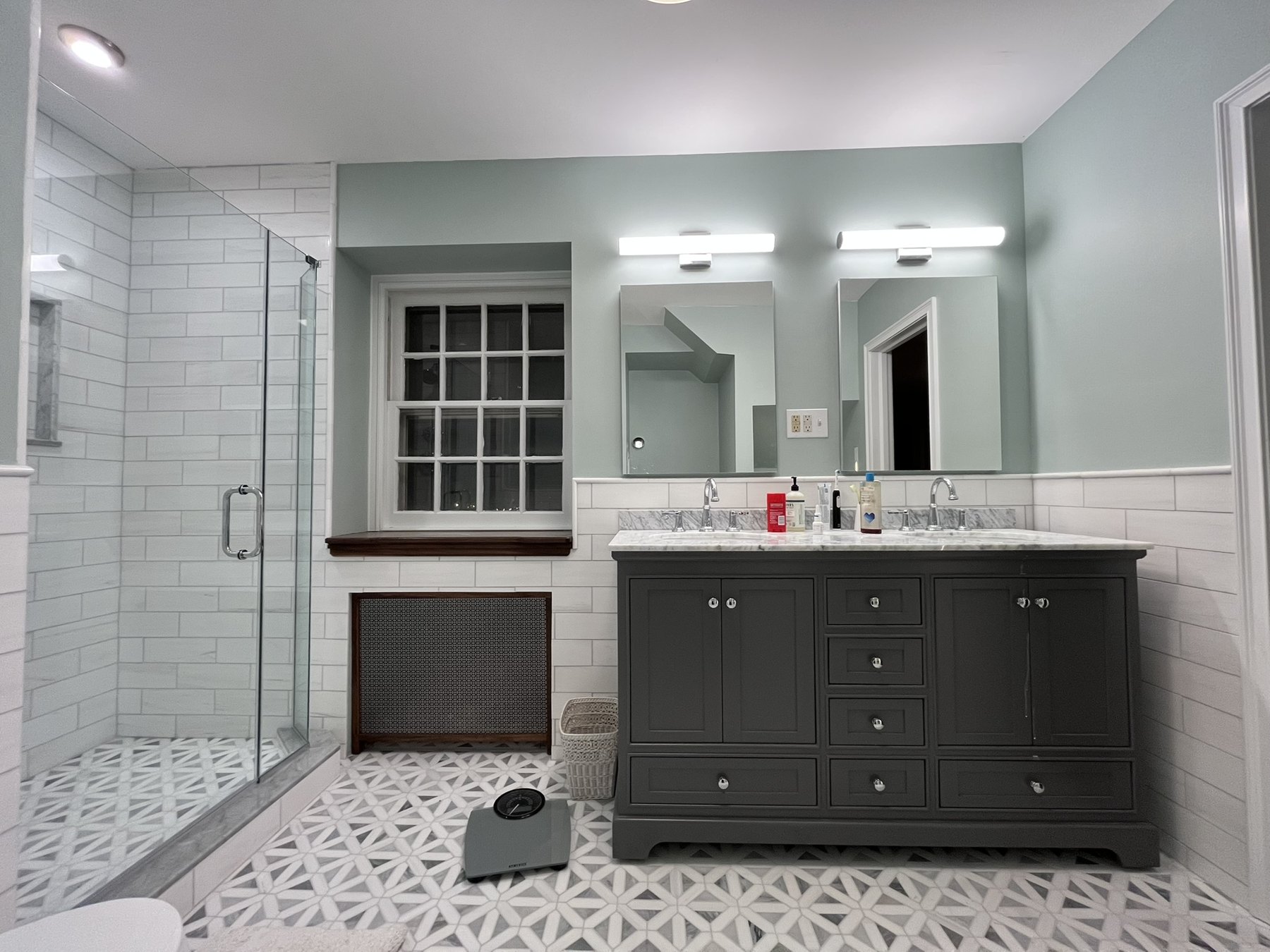 Primary bathroom with vanity, shower, window and fitted radiator grille
