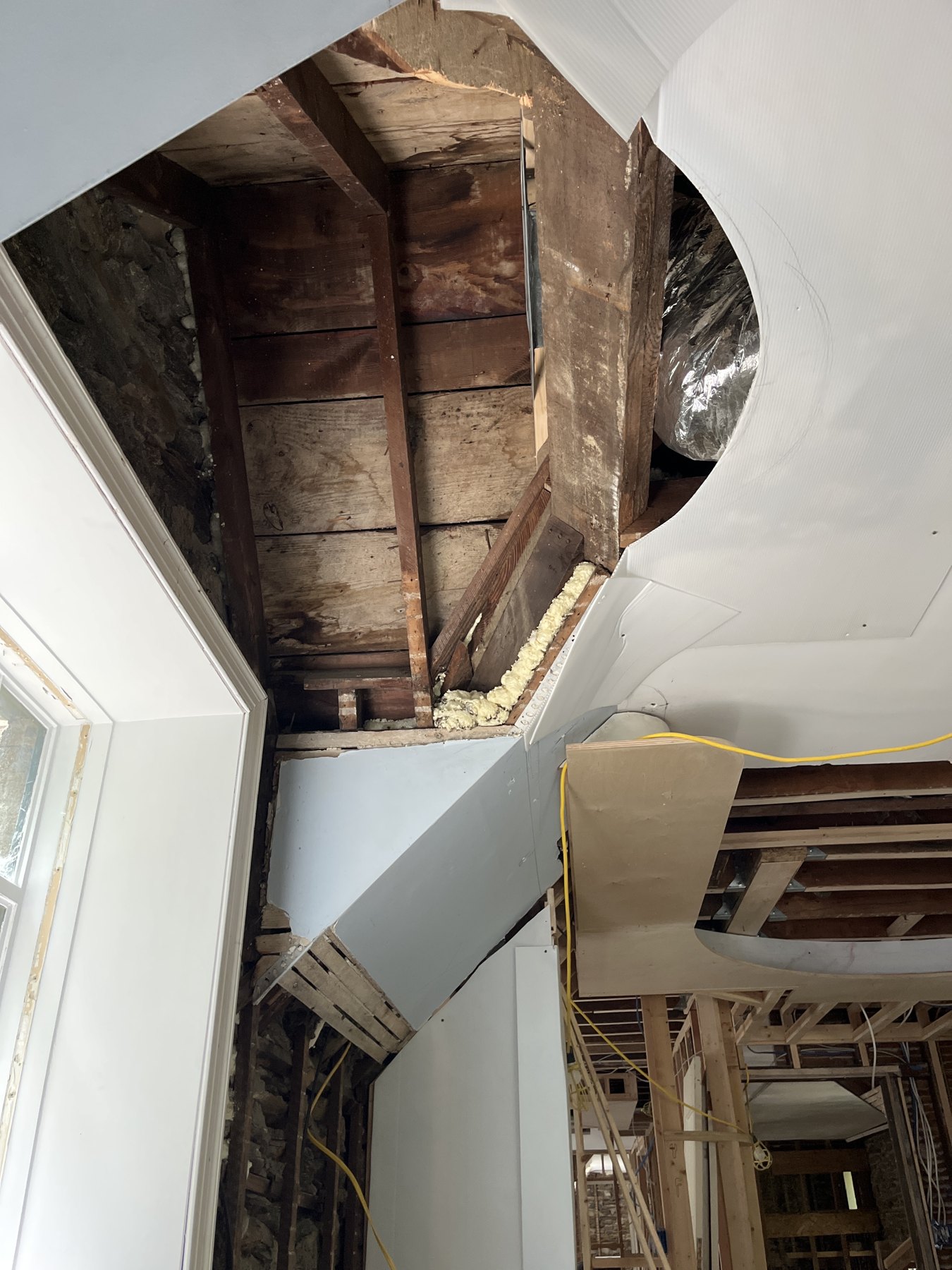 Existing roof timbers and curved enclosure layout exposed during construction