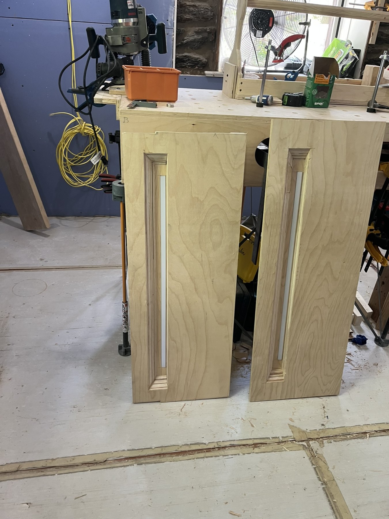 Two plywood routing templates with long recessed openings on the site bench