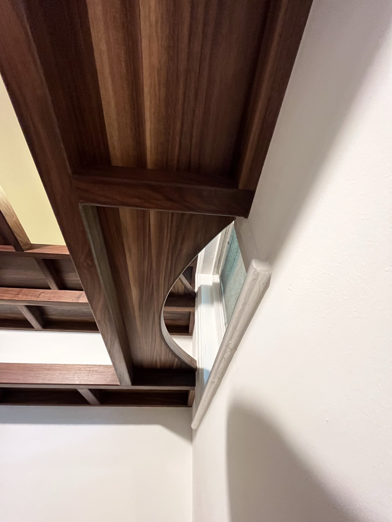 Curved walnut shelf edge and trim viewed from below