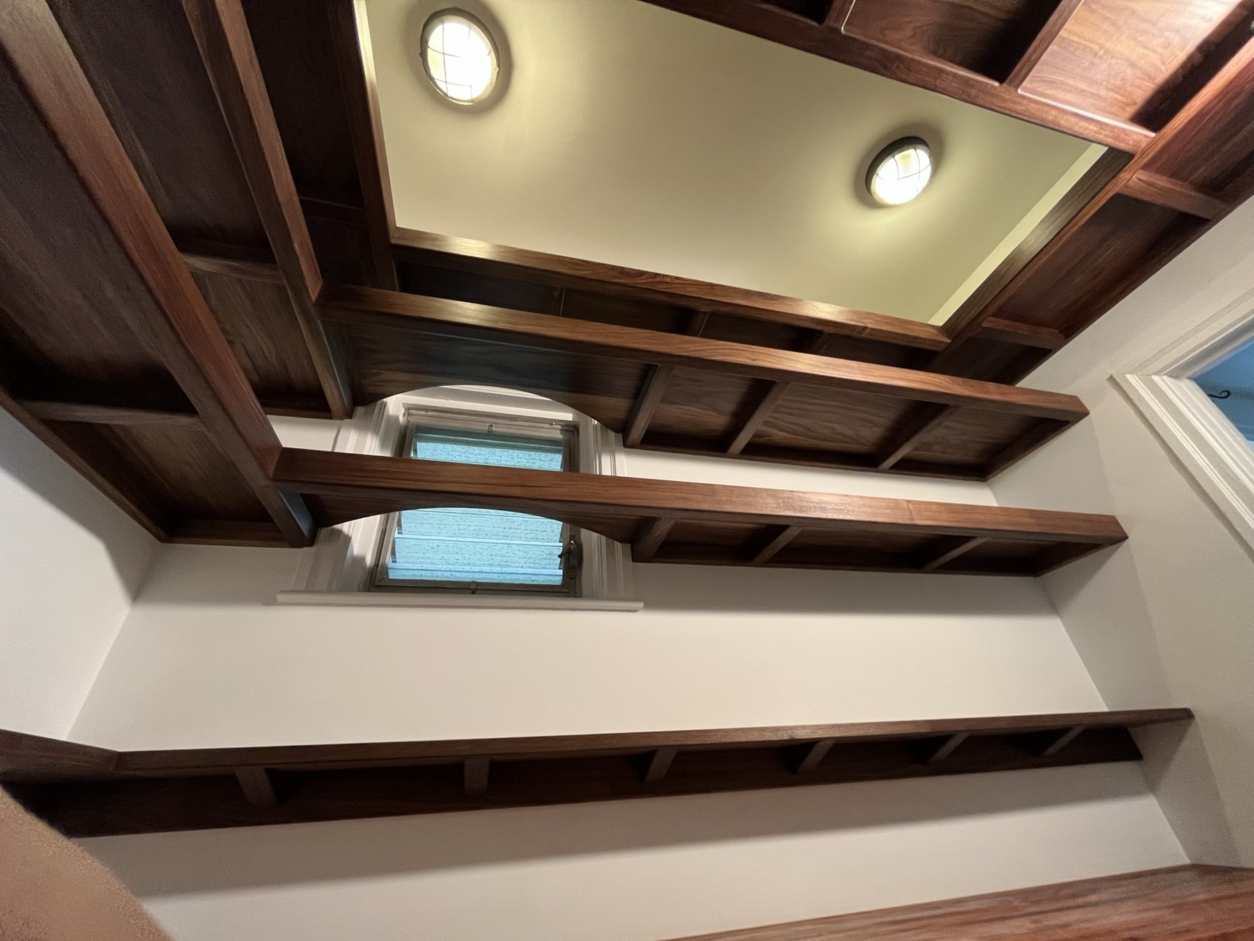 Upper walnut framework framing the pantry lighting and window