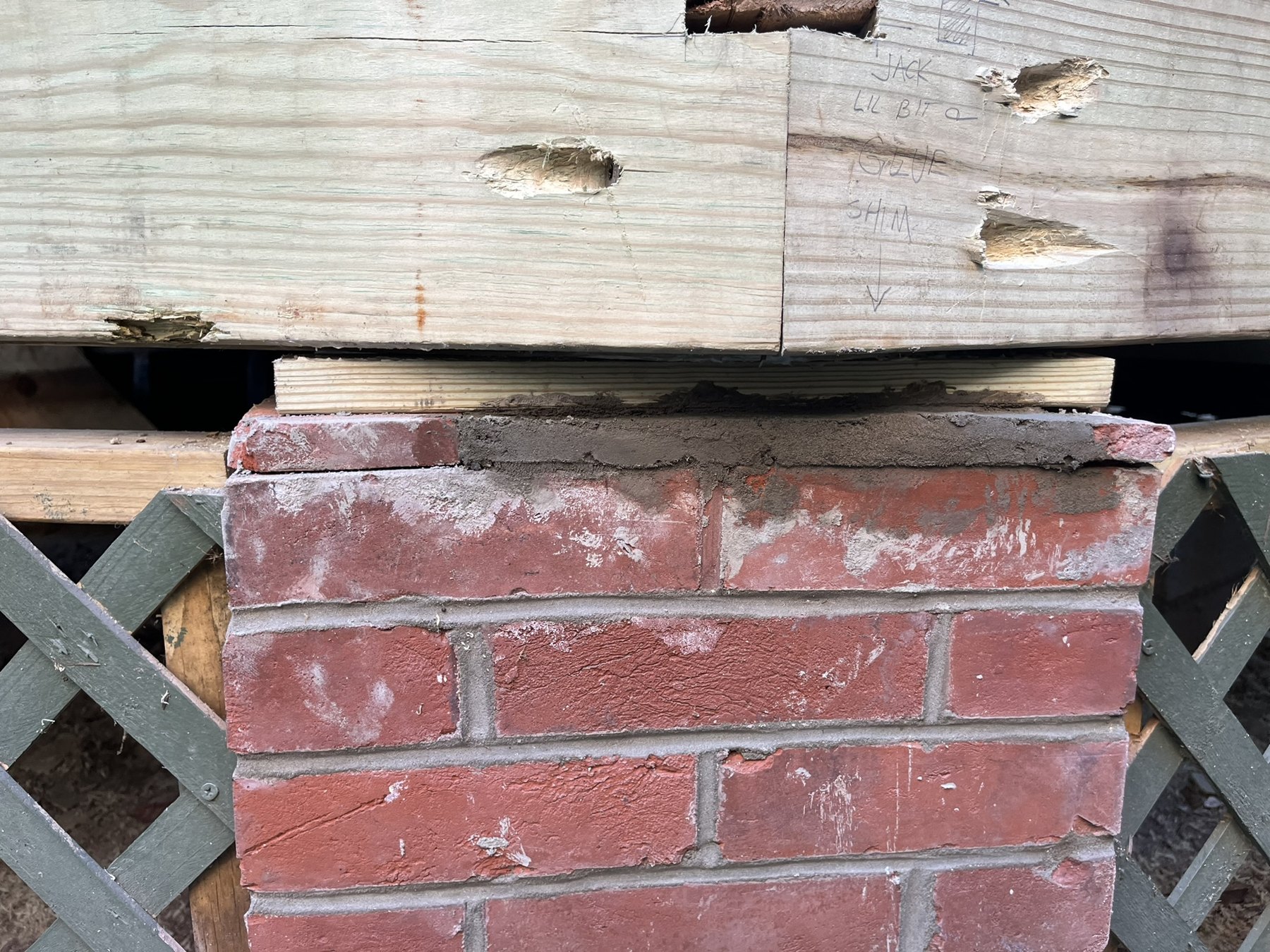 Timber porch framing bearing on a repaired brick pier