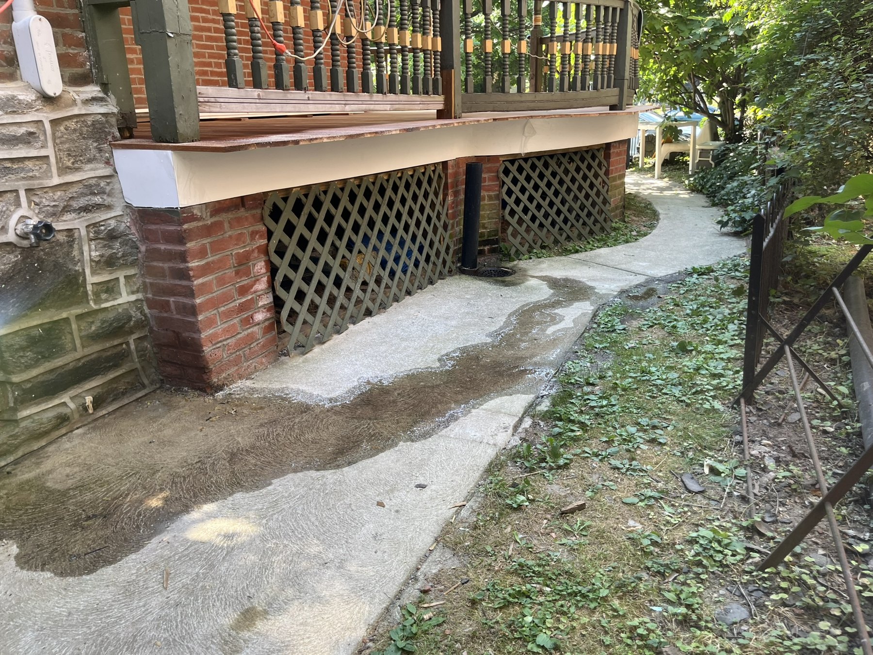Victorian porch with wood decking, railing, brick piers and lattice