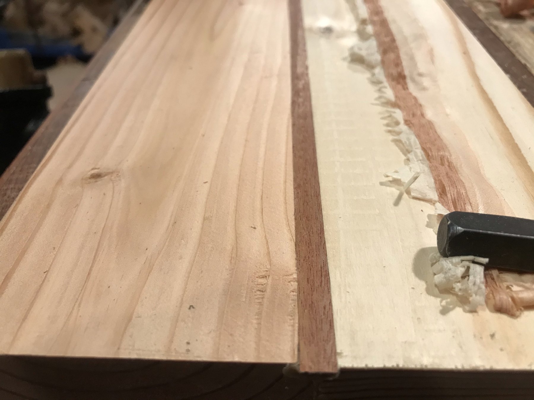 Hand plane and wood shavings beside a table component